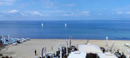 a beach with sailboats in the water and a group of tents at Umbrella Apartment in Perea