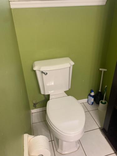 a bathroom with a white toilet in a green wall at One Bed Suite near Beaches and Downtown Sarasota in Sarasota