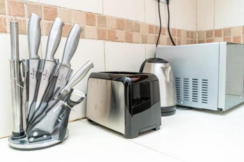 a kitchen counter with a toaster and utensils at Sofitel Executive 4 bedrooms Milimani in Kisumu