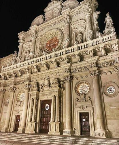 a large building with a clock on top of it at Palazzo Quey in Lecce