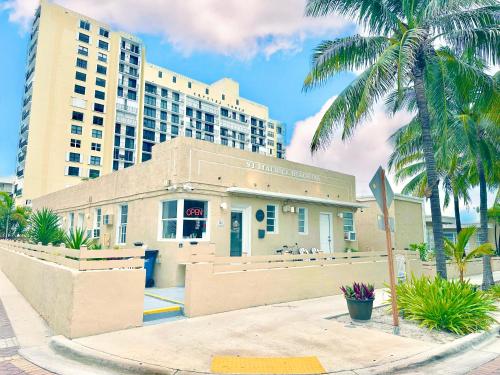 a building in front of a tall building with palm trees at St Maurice Beach Inn in Hollywood
