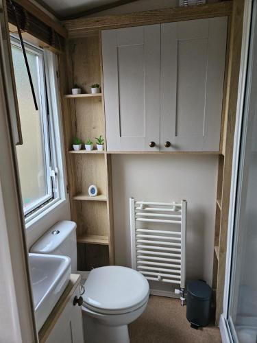 a small bathroom with a toilet and a sink at Roadnights Retreat in Heysham