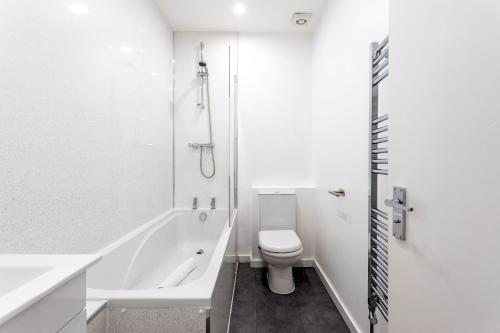 La salle de bains blanche est pourvue d'une douche et de toilettes. dans l'établissement Refurbished StJohns Hill Apartment, à Londres