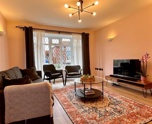 uma sala de estar com um sofá e uma televisão em Nature Inspired Bungalow with 3 rooms - 10 mins from Manchester Airport em Timperley
