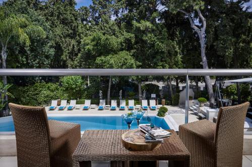 a patio with a table and chairs next to a pool at Rodos Park in Rhodes Town