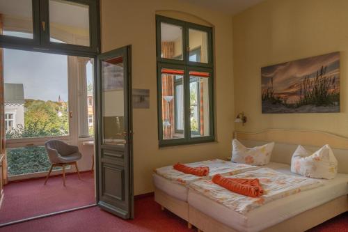 ein Schlafzimmer mit einem Bett mit orangefarbenen Kissen darauf in der Unterkunft Villa Stock in Heringsdorf