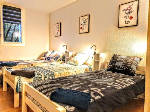 - une chambre avec 2 lits et une fenêtre dans l'établissement La Casa Picasso, à Villepinte