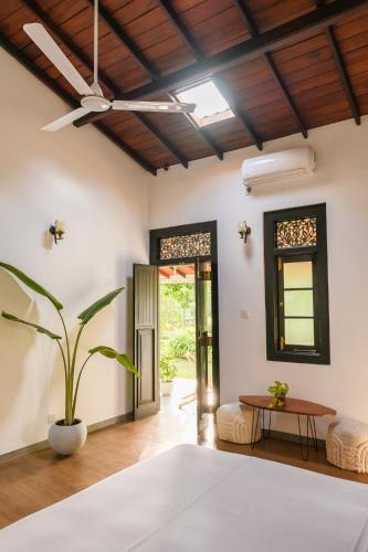 a living room with a ceiling fan and a table at Roots Retreat in Unawatuna