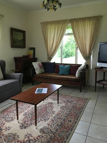 uma sala de estar com um sofá e uma mesa de centro em Honeywood Farm em Heidelberg