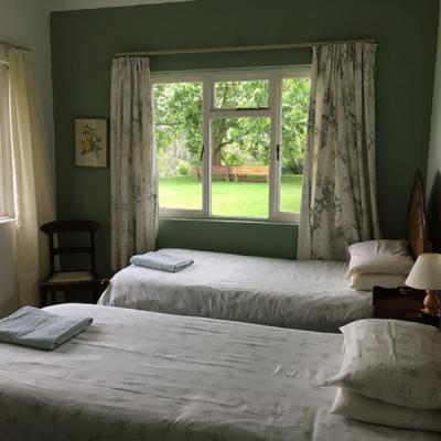 Duas camas num quarto com uma janela em Honeywood Farm em Heidelberg