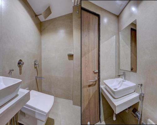 a bathroom with two sinks and a shower and a mirror at Atithi Int'l-International Airport in Mumbai