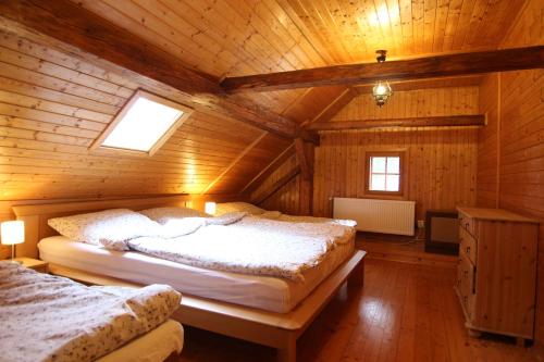 a bedroom with two beds in a wooden cabin at Malebná chalupa u Javorníku na Šumavě in Vacov