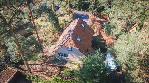 uma vista aérea de uma casa com um telhado em Wellnesshuis met jacuzzi en sauna in het bos em Lunteren