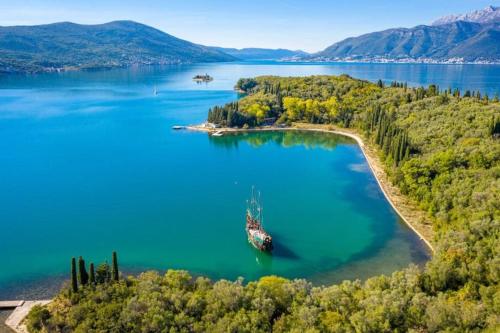an island in a lake with a boat in it at Apartment Potpara in Tivat