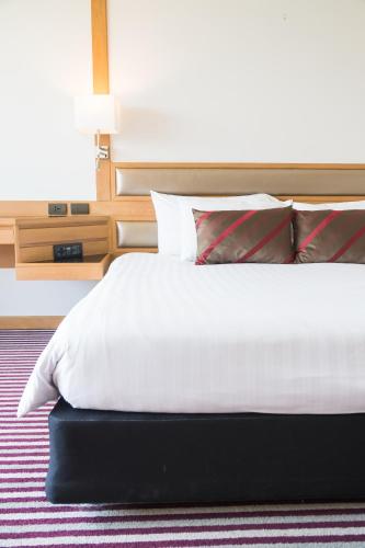 Un dormitorio con una cama blanca con almohadas rojas y blancas en Premascape, en Kianyaga