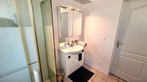 een badkamer met een wastafel en een spiegel bij Charmante maison, idéalement située in Fitou