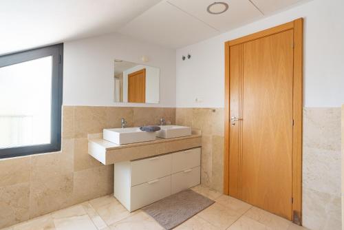 a bathroom with two sinks and a wooden door at Modern townhouse with stunning view in Fuengirola