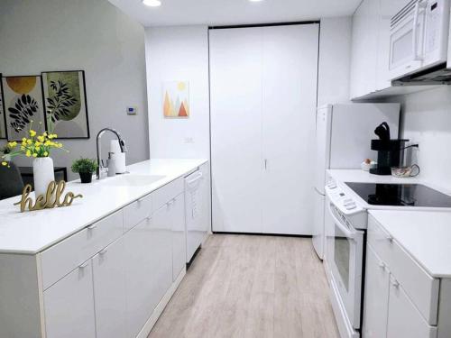 629 Lofts 802 - A KCM Property في كليفلاند: مطبخ أبيض مع أجهزة بيضاء ودواليب بيضاء