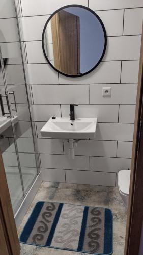 a bathroom with a sink and a mirror at Apartamenty Simon in Mielno