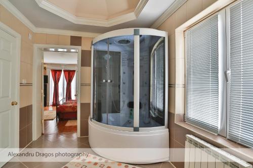 a large glass shower in a room next to a window at Casa Iulia in Haţeg