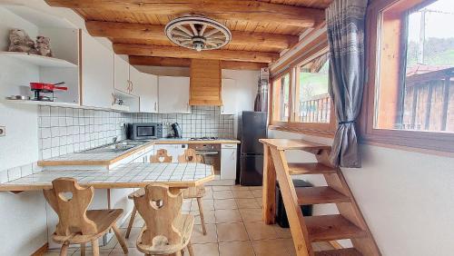 - une cuisine avec une table et quelques tabourets en bois dans l'établissement Appartement 1 chambre idéalement situé, à Domancy