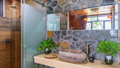 a bathroom with a stone sink on a counter at Tam Coc Serenity Hotel & Bungalow in Ninh Binh