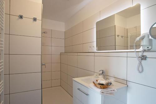 een badkamer met een wastafel en een spiegel bij Gasthof Lafrenz in Hamdorf