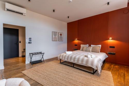 een slaapkamer met een groot bed en een rode muur bij Hôtel Le Manoir in Marche-en-Famenne