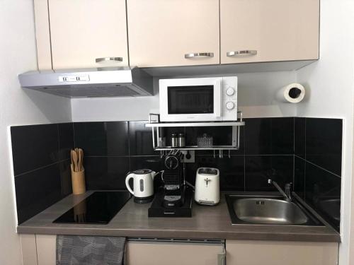 a kitchen with a sink and a microwave at Secret Lakeside in Frauenkirchen