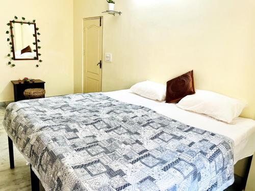 een slaapkamer met een bed met een quilt bij sai bliss in Puttaparthi