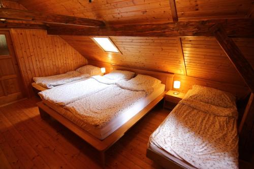 an attic bedroom with two beds in a cabin at Malebná chalupa u Javorníku na Šumavě in Vacov