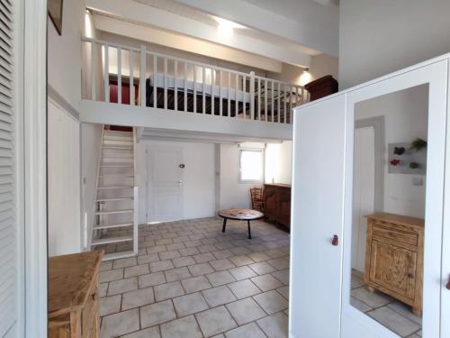 une chambre avec une mezzanine et un escalier dans l'établissement Maison avec piscine et jardin proche mer, La Rochelle, à La Rochelle