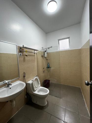 a bathroom with a toilet and a sink and a shower at SDC Suite Home II in Lahad Datu