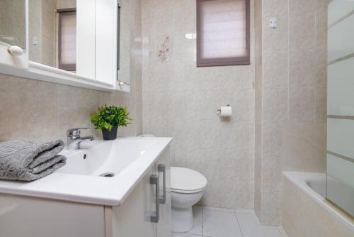 La salle de bains est pourvue d'un lavabo blanc et de toilettes. dans l'établissement Estudio Jardín del Mar, à Torrevieja