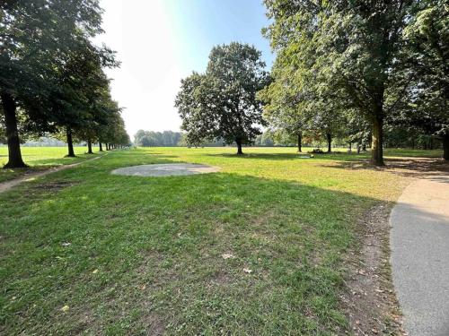 un parc avec un étang dans l'herbe et les arbres dans l'établissement Oasi a due passi dal Parco Nord Milano, à Bresso
