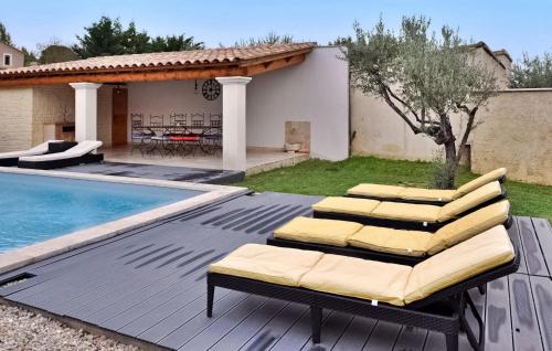 a group of chairs sitting on a deck next to a pool at La Maison De Celine in Beaumes-de-Venise
