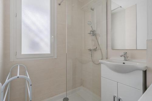 baño blanco con ducha y lavamanos en L’oasis en Seyssinet-Pariset