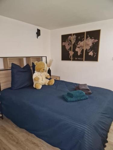 un ours en peluche assis sur un lit dans l'établissement Charming apartment near La Défense, Paris, à Bezons