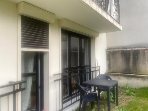 a table and two chairs sitting on a balcony at Grand studio avec terrasse et jardin in Saint-Maur-des-Fossés