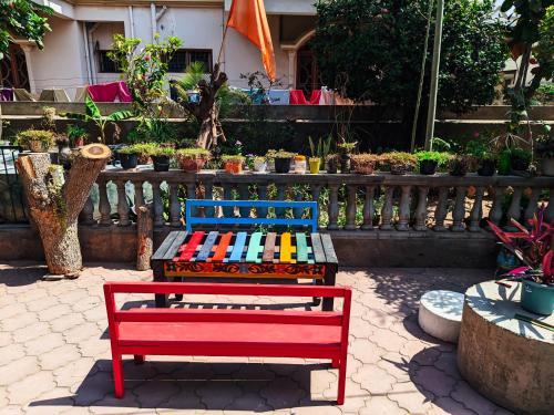 a red and blue bench sitting next to a fence at Jaat House in Bhuj