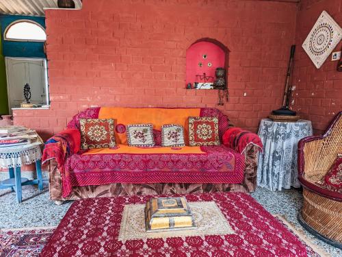 a living room with a red brick wall at Jaat House in Bhuj