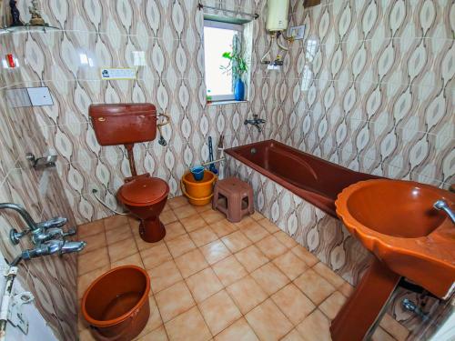 a bathroom with a tub and a toilet and a sink at Jaat House in Bhuj