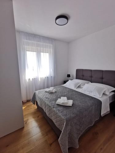 a bedroom with a large bed with two towels on it at Gita Suite in Orebić