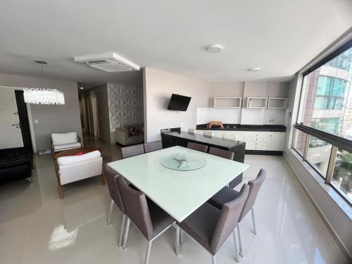 Una cocina y un comedor con una mesa y sillas blancas. en Guarapari Praia - 4 quartos e 2 suítes com ar quiosque 16, en Guarapari