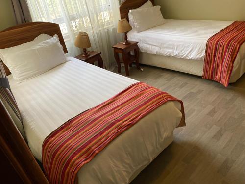 ein Hotelzimmer mit 2 Betten und 2 Lampen in der Unterkunft Runda two bedroom in Nairobi