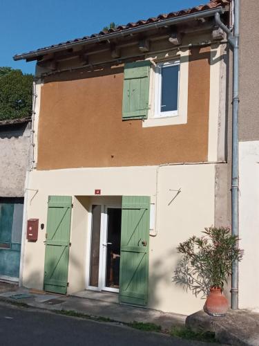 a house with green doors and a plant in front at Volets Verts in Montauriol