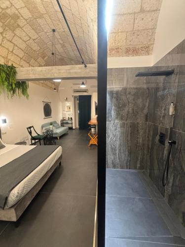a bedroom with a bed and a stone wall at Vittoria in Polignano a Mare