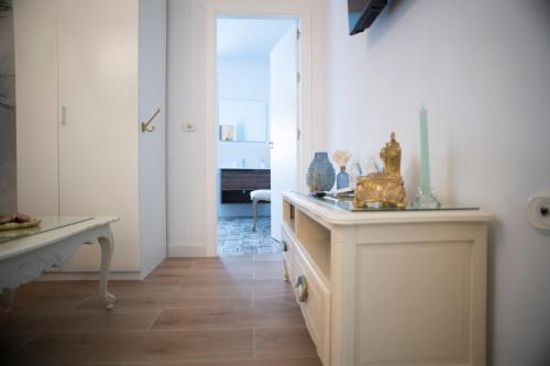 - un couloir avec une table et des vases dans l'établissement Palacete de La Alameda - Adults Only-, à Cadix