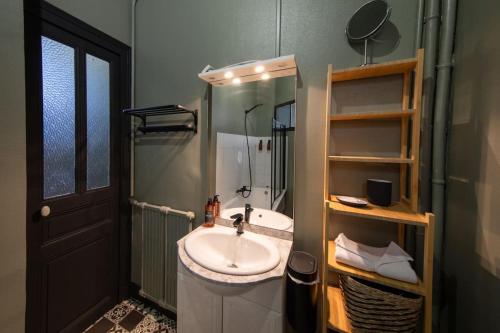 a bathroom with a sink and a shower and a mirror at Athos, l'élégant in Orléans