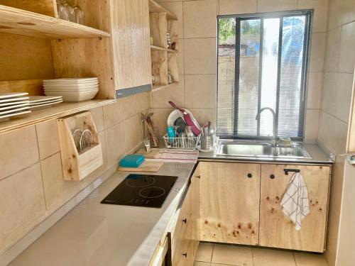 cocina con armarios de madera, fregadero y ventana en Urban Lodge Providencia, en Santiago